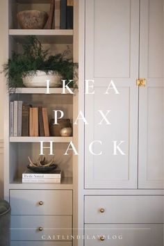 an open bookcase with books and plants on it in front of a white wall