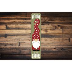 a welcome gnome sign hanging on a wooden wall