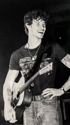 black and white photograph of a man holding a guitar