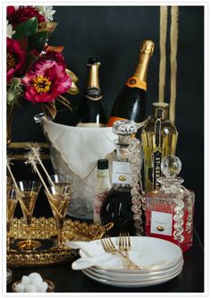 a table topped with plates and glasses filled with champagnes, wine bottles and condiments