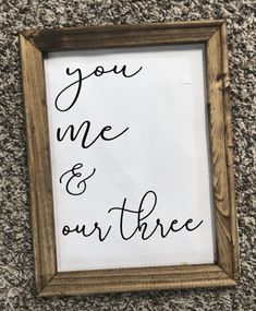 a wooden frame with the words you me and our three written in black ink on it