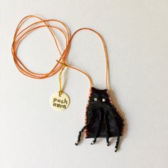 an orange cord with a black octopus on it and a white tag attached to it