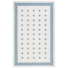 a blue and white area rug with dots on the border, in front of a white background