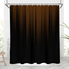 a black and brown shower curtain hanging on a white wall next to a chair in front of a window