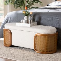 a white bench sitting on top of a bed next to a wooden headboard and foot board