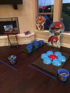 a table with cups and bowls on it in front of a fireman's hat