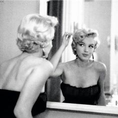 a woman is looking at herself in the mirror