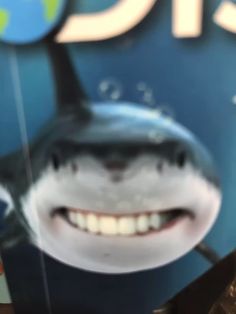 a close up of a toothbrush with a smiling shark on it's side