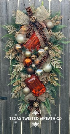 a christmas wreath hanging on the side of a wooden fence