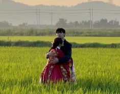 a man and woman embracing in the middle of a field