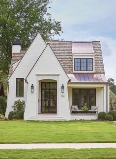 a white house sitting on top of a lush green field