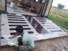 a man kneeling down on the ground next to a building