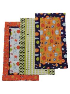 three pieces of fabric with pumpkins and leaves on them, all in different colors