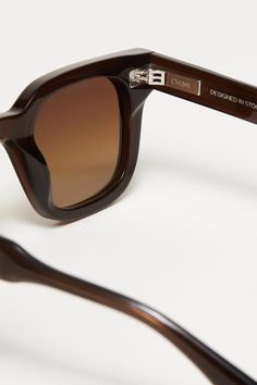 The 04 Sunglasses in Brown by CHIMI are a stylistic silhouette creating dynamic contrast with a strong rectangular frame and slim sides. Handcrafted in Mazzucchelli acetate with silver-tone hardware rivets and pointed temple tips, finished with deep bevel cuts along the UV-protective CR39 lenses. Each pair comes with a branded case, pouch and cleaning cloth. Sizing + Details → 100% Acetate 100% UVA+UVB Protection Medium Reduction Of Sun Glare Anti-Scratch, Anti-Shatter, Distortion-Free Frame 142mm, Nose 24mm, Temple Lens 145mm, Lens Thickness 2mm Free Frames, Rivets, Cleaning Cloth, Silver Tone, Lenses, Sunglasses