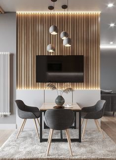 a living room with a table and chairs in front of a flat screen tv mounted on the wall