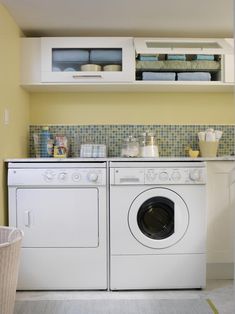 a washer and dryer in a small room with yellow walls on the wall