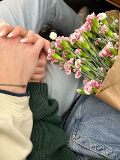 a person sitting down with flowers in their lap