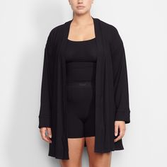 Perfect for lounging and layering over sleepwear, the Soft Lounge Robe is composed of super-soft modal ribbed fabric that drapes effortlessly in all the right places. This short robe features an adjustable self-tie belt and functional side pocket at inseam. | SKIMS Robe | Black | Soft Lounge Oversized Fall Robe For Loungewear, Oversized Fall Loungewear Robe, Tie Waist Wrap Sleepwear For Loungewear, Tie Waist Wrap Sleepwear, Wrap Sleepwear With Tie Waist For Loungewear, Long Sleeve Modal Sleepwear For Loungewear, Long Sleeve Sleepwear With Tie Waist For Lounging, Long Sleeve Tie Waist Sleepwear For Lounging, Spring Lounging Wrap Sleepwear