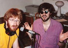 two men sitting next to each other in front of microphones