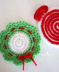 two crocheted coasters with red and green designs on them, one has a candy cane in the center