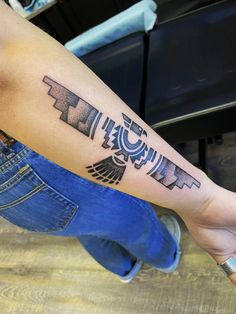 a man's arm with an egyptian tattoo design on the left side of his arm