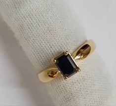 a gold ring with a black stone on it