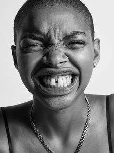 a black and white photo of a woman with her mouth open, wearing a necklace