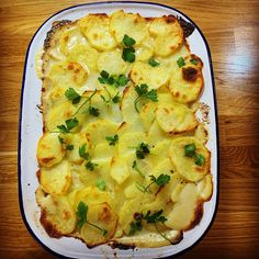 a casserole dish with potatoes and parsley on top, ready to be eaten