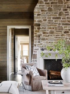 a living room filled with furniture and a fire place in front of a brick wall