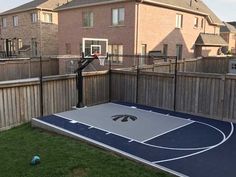 a backyard with a basketball court and fence