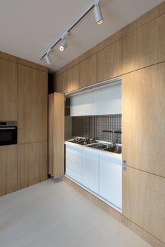 an empty kitchen with wood paneling and white counter tops