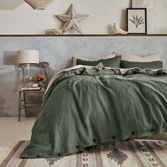 a bed in a bedroom with green linens and starfish decorations on the wall