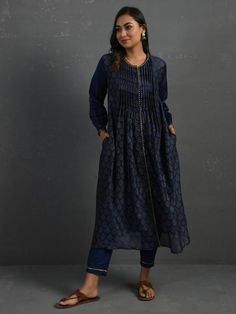 A gold hand block printed front open chanderi kurta with pintucks, gota details, full-length sleeves with gathers. This indigo kurta comes with a separate matching mul slip and pants with elasticated and drawstring adjustable waistband Kurta measurements (in Inches): Size S: Bust - 39", Waist - 39" Size M: Bust - 42", Waist - 42" Size L: Bust - 45", Waist - 45" Length: 47", Sleeve length: 21" Pant Measurements (in Inches): Size S: Waist - 30-32" Size M: Waist - 33-35" Size L: Waist - 36-38" Leng Indigo Cutdana Kurta For Eid, Blue Long Sleeve Kurta With Gota Work, Elegant Long Sleeve Sets With Pintucks, Indigo Designer Straight Kurta, Designer Indigo Straight Kurta, Indigo Designer Wear Straight Kurta, Indigo Kurta For Navratri, Indigo Kurta For Navratri Festive Season, Indigo Festive Kurta For Navratri