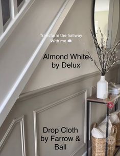 a white vase with flowers on top of a shelf next to a mirror and stairs