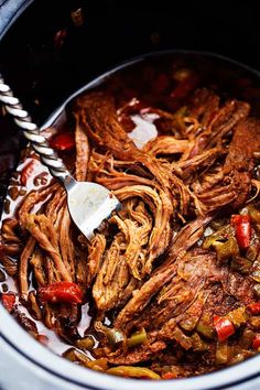 the meat is being cooked in the crock pot with a ladle on it