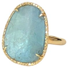 Designer Getana & Co. This ring is a gorgeous light blue apatite slice with a diamond halo. This ring practically glows. Oval-ish apatite approximately 20.5mm x 16mm (approximately 8 carats) with beautiful 'honeycomb' back. Apatite is surrounded by small round prong set diamonds, approximately .17tdw. 14 karat yellow gold. Overall ring approximately 23mm x 18.5mm. Size 7 Luxury Turquoise Gemstone Ring With Oval Cabochon, Luxury Oval Turquoise Ring With Patina, Luxury Turquoise Oval Topaz Ring, Luxury Oval Gemstones Fine Jewelry, Luxury Artisan Oval Turquoise Ring, Luxury Oval Fine Jewelry Gemstones, Luxury Artisan Turquoise Oval Ring, Unique Yellow Gold Ring, 3 Carat Diamond Ring