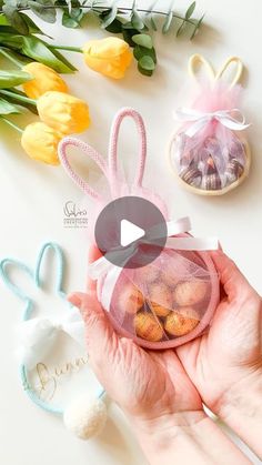 a person holding a small bag filled with candies next to flowers and bunny ears