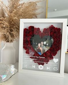 a white frame with a red rose heart in the shape of a photo on it