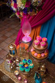 a table topped with lots of cupcakes and cakes