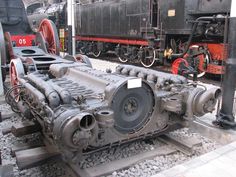 an old train engine sitting on the tracks in front of a locomotive and other trains