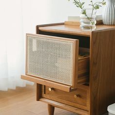 a wooden table with drawers and a vase on top