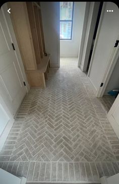 an empty hallway with white walls and wooden stairs