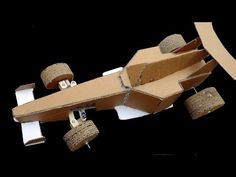 an airplane made out of cardboard with wheels attached to it's sides and some corks hanging from the side