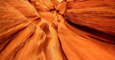 a narrow canyon in the desert with red rocks and water flowing down it's sides