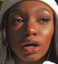 a close up of a person wearing ear buds and a white hat on her head