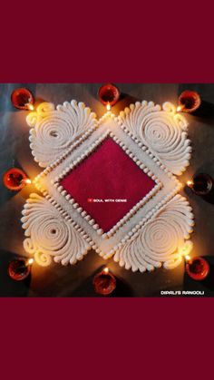 an intricately decorated diya with candles around it