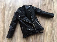 a black leather jacket laying on top of a wooden floor