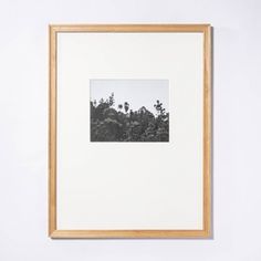 a black and white photo hanging on the wall next to a wooden framed artwork piece