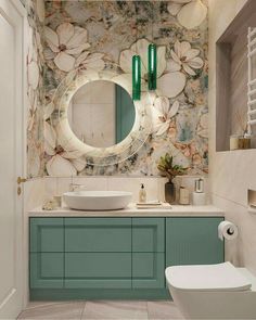 a bathroom with green cabinets and a white toilet sitting next to a sink under a round mirror