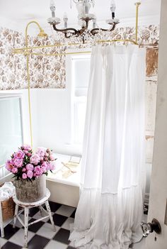 a bath room with a tub and a flower pot on the floor next to a window